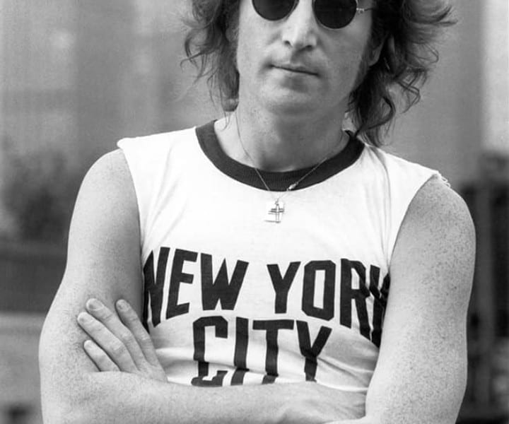 After taking portrait photos of John Lennon's face on the roof of Lennon's New York apartment, I decided to take more photos for publicity.  I had given John a NYC T-shirt a year earlier and with the skyline all around I asked John if he still had it as this would be the perfect place to wear it.  John went and put it on to make this now iconic photo.