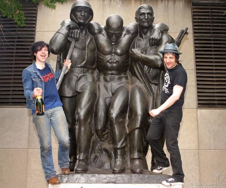 Ryan gets a bottle of champagne and celebrates with Jesse on the Coast Guard Statue in the park.