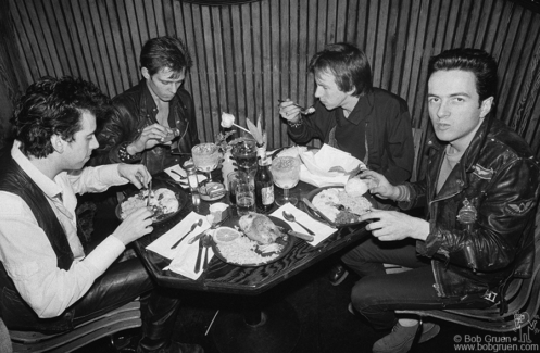 (L-R) Mick Jones, Paul Simonon, Topper Headon and Joe Strummer of The Clash eating during their tour of the USA. February 1979. Image #: Clash279_13-16_1979 © Bob Gruen Clash, USA - 1979